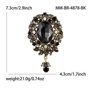 Detailed macro view of vintage Baroque brooch with black gemstone and rhinestone carvings