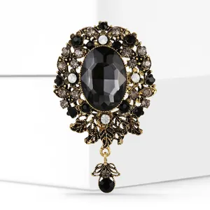 Close-up of vintage baroque brooch featuring a black oval gemstone and gold-toned metalwork