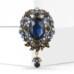 Detailed close-up of a vintage Baroque brooch with deep blue stone and crystal accents