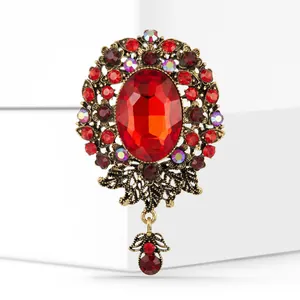Close-up of vintage baroque brooch with red oval stone and ornate gold metalwork detail