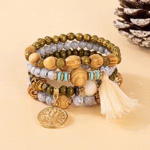 Detail of bohemian multilayer beaded bracelet with tree of life charm and soft tassel