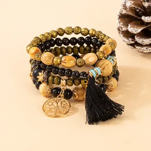 Macro detail of bohemian layered wooden beads with Tree of Life charm and black tassel