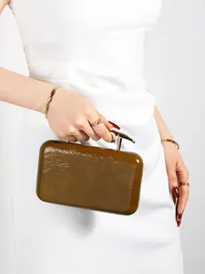 Detail of olive brown pleated PU leather bag with sculptural gold metal handle