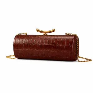 Detail der dunkelbraunen Kroko-Baguette-Tasche mit markanter goldener Metallschließe
