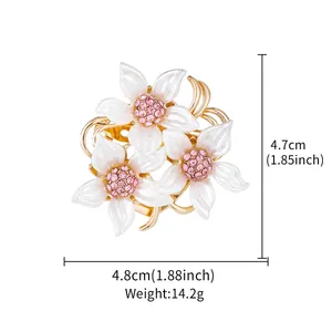 Detailed view of 4.8cm floral brooch with white enamel petals and pink crystals