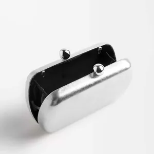 Detail view of silver hard shell clutch with metallic texture and ball clasp closure