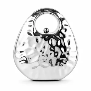Detailed view of silver hammered texture metal evening bag with round ring handle
