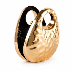 Elegant gold oval evening clutch bag with hammered texture and round hollow handle