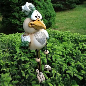 Close-up of funny resin garden chicken statue with big eyes and hanging legs
