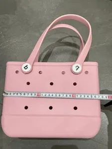 Detail shot of pink EVA beach bag with holes and white handles showing 30cm width
