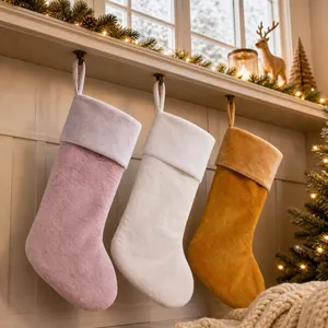 Three plush Christmas stockings in pink, white, and yellow hanging on a cozy fireplace mantel
