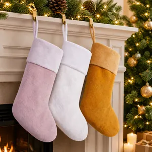 Detailed macro view of three plush Christmas stockings in pink, cream and yellow colors