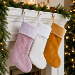 Set of three large plush Christmas stockings in lavender white and ginger on fireplace
