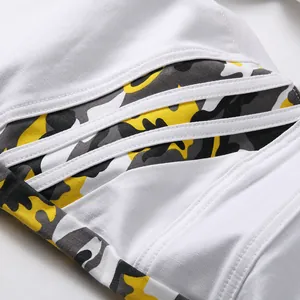 Jean slim pour homme en denim blanc avec patchwork camouflage jaune et détails de rayures