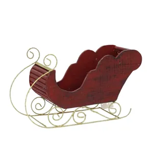 Traîneau de Noël vintage en bois rouge avec patins dorés pailletés sur fond blanc neutre