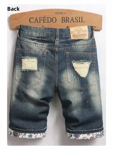Detailed back view of distressed denim shorts with ripped pockets and floral patterned lining