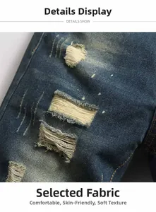 Detailed view of distressed blue denim jeans with hand-drawn paint splatters and ripped holes