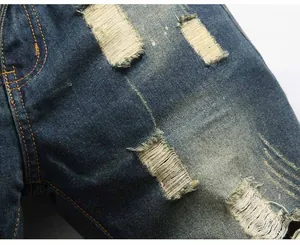 Macro shot of distressed denim jeans with ripped holes and detailed cat whisker texture