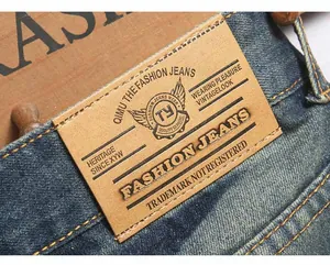Macro shot of dark blue denim waist featuring vintage leather patch and contrast stitching