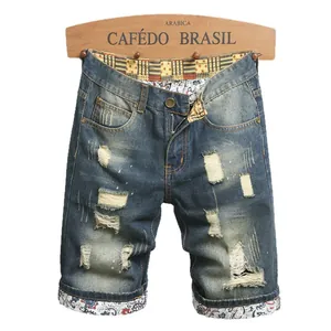 Distressed denim shorts for men with ripped holes and paisley patchwork detailing