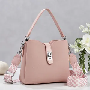 Detail of pink bucket bag with silver twist lock and jacquard patterned wide shoulder strap