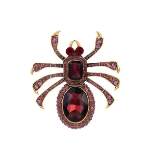 Close-up of spider brooch with gold alloy base and red rhinestone jewel setting