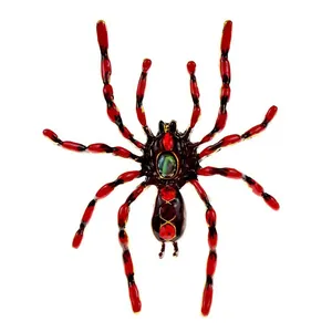 Detailed close-up of spider brooch with red rhinestones and green rainbow stone inlay