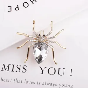 Macro detail of a gold spider brooch with sparkling crystals and a pear-cut centerpiece