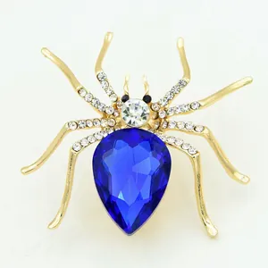 Macro shot of spider brooch with large blue gemstone and sparkling rhinestone detailing
