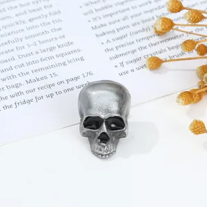 Macro detail of skull-shaped metal ring with distressed finish on vintage book pages