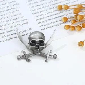 Detail of vintage silver pirate skull and cross swords brooch with black rhinestone accents