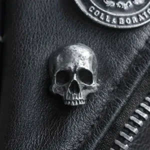 Retro punk skull rivet on black leather background with vintage silver finish