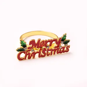 Macro shot of golden Merry Christmas napkin ring with red lettering and holly leaf details
