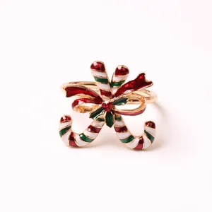 Close-up of golden Christmas napkin ring with candy cane and red bow tie design