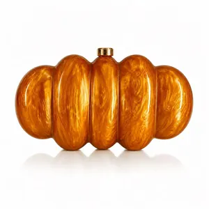 Dettaglio macro della borsa a zucca in acrilico ambra con chiusura in metallo dorato