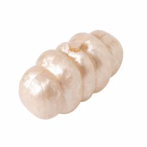 Dettaglio della texture marmorea bianco perla su una lussuosa pochette da sera in acrilico