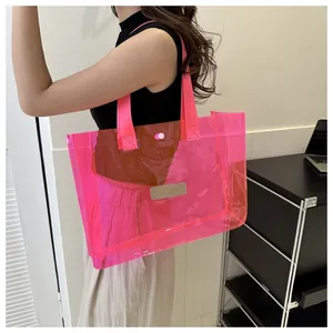 Detail of pink transparent PVC tote bag featuring snap button closure and ribbon handle