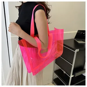 Detail of transparent fluorescent pink PVC tote bag with stylish brand tag and thick strap