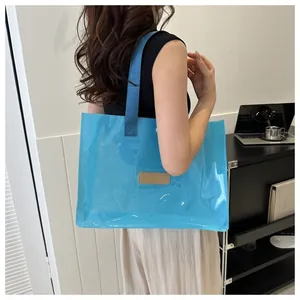 Close-up of a large blue transparent tote bag with durable woven straps and leather patch