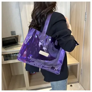 Close-up of purple transparent PVC tote bag with leather logo patch and nylon strap