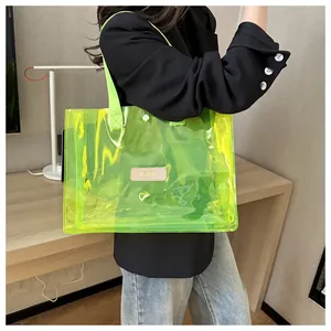 Detail of neon green transparent tote bag showing waterproof PVC and brand patch