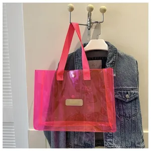 Detail of neon pink transparent PVC tote bag with durable shoulder straps and leather patch