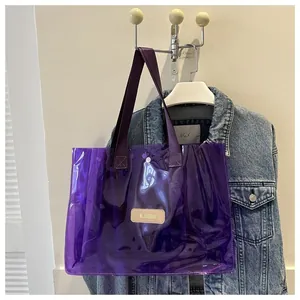 Detail of purple transparent PVC tote bag with snap button closure and woven handles
