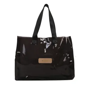 Black semi-transparent tote bag with nylon handles and brown leather patch logo
