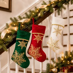 Detailed view of velvet Christmas stockings with gold snowflake embroidery hanging on stairs