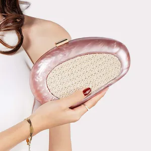 Detail of pink marble acrylic evening bag with woven panel and gold metal clasp