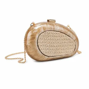 Detail of marble resin shell clutch with raffia inlay and gold metal chain strap