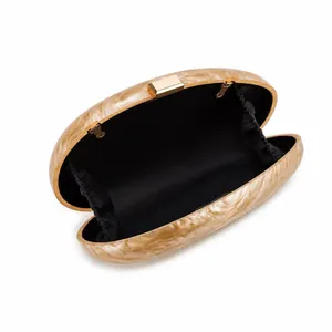 Macro view of shell evening clutch with marble pattern and golden metal frame