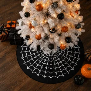Detail of black Christmas tree skirt with white spider web pattern on wooden floor