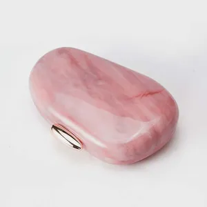 Detail of pink marble acrylic evening clutch with polished rose gold metal clasp